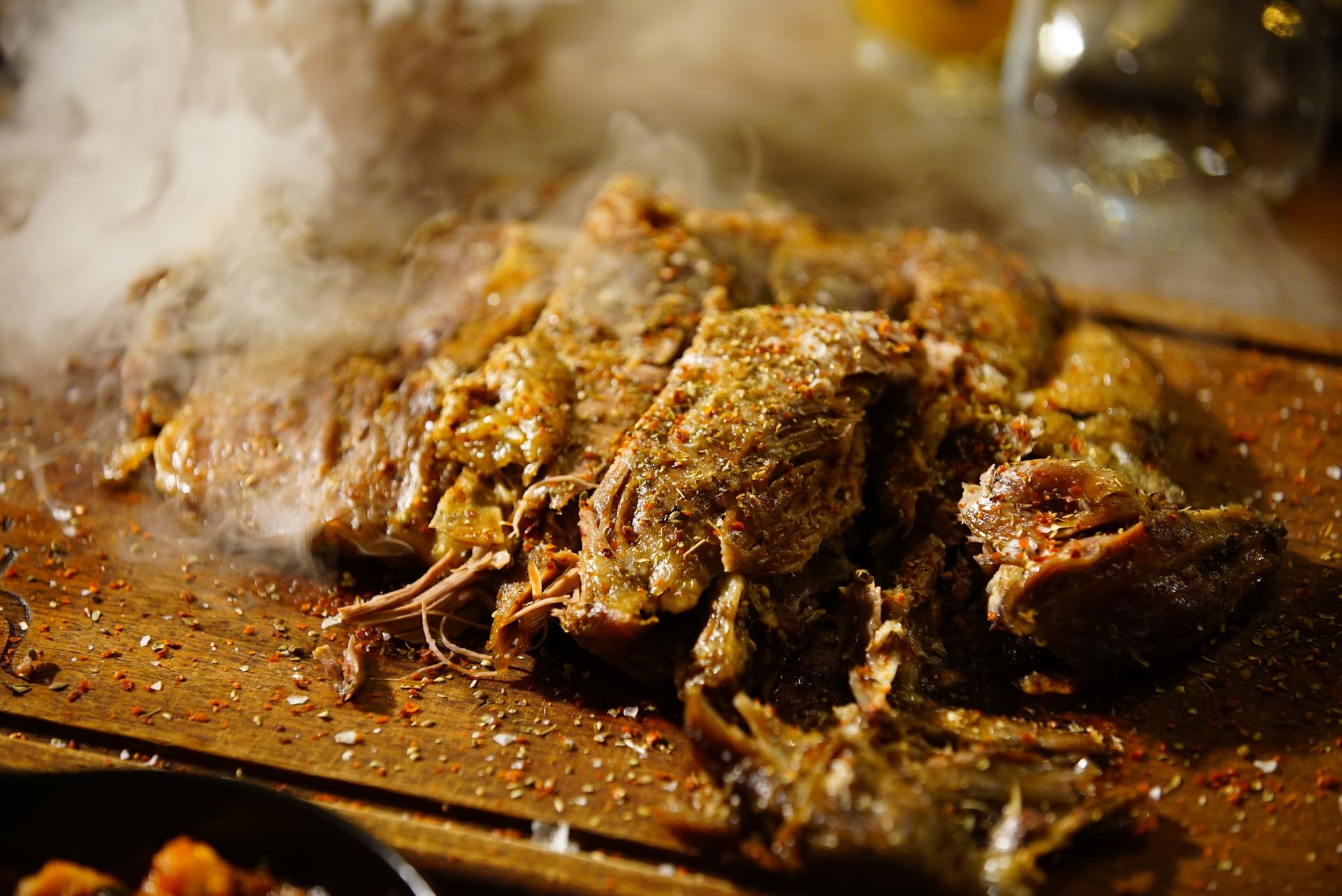 Steaming pulled pork piled on a wooden board